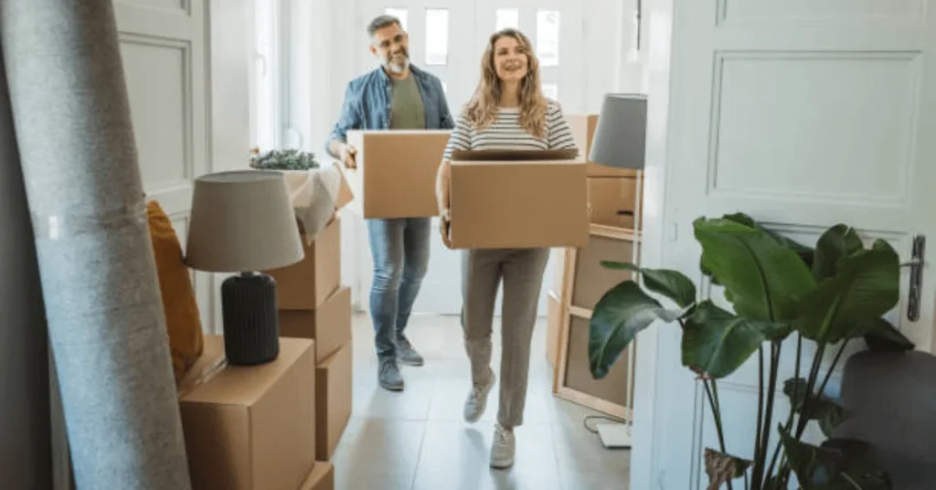 A man and woman carrying boxes